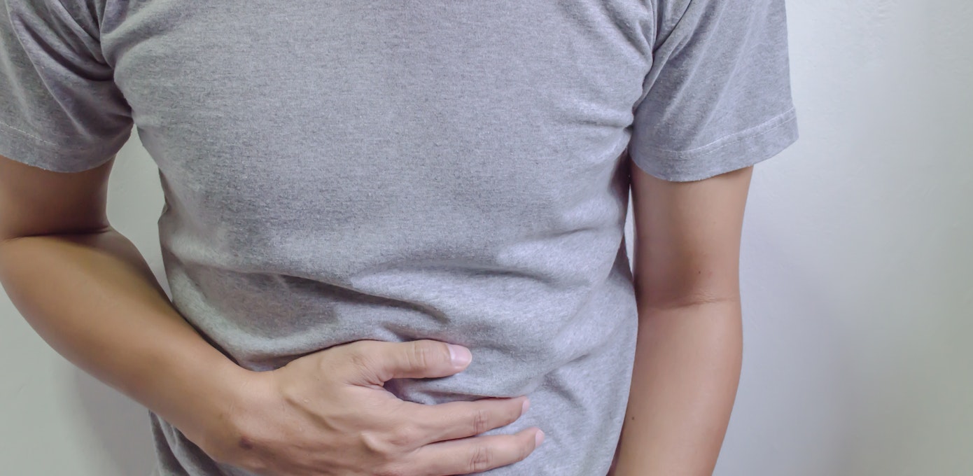 An image depicting a person suffering from abdominal pain that get worse after eating symptoms