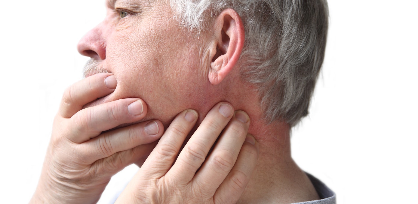An image depicting a person suffering from jaw stiffness symptoms