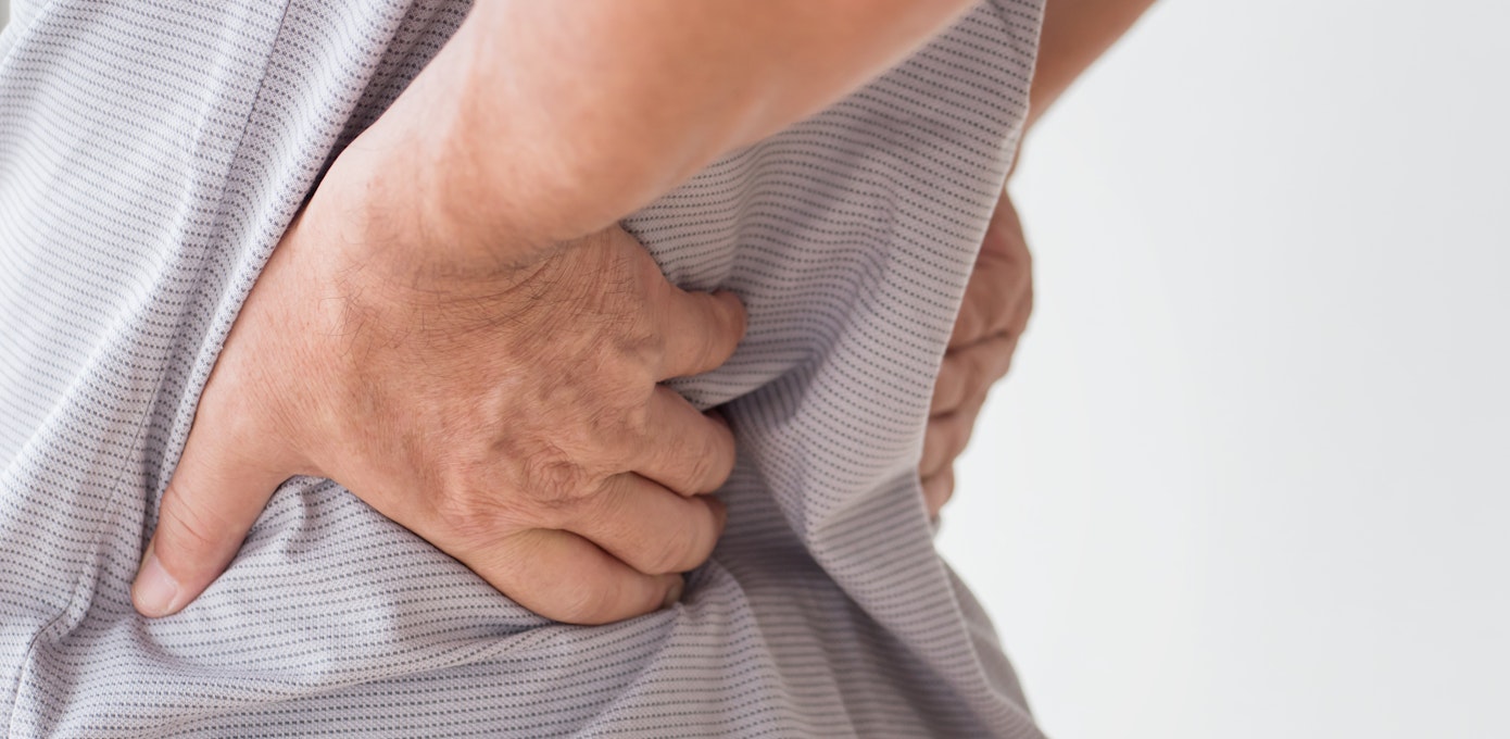 An image depicting a person suffering from painful back lump symptoms