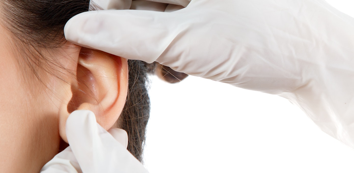 An image depicting a person suffering from waxy ear discharge symptoms